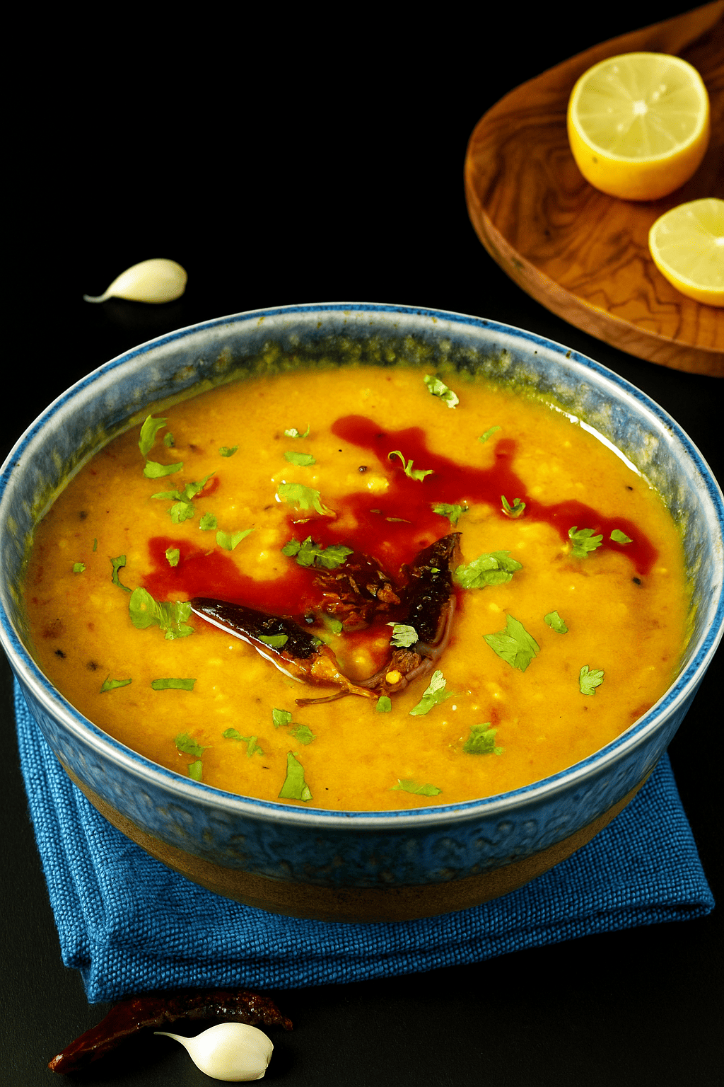 Ein aromatisches indisches Linsengericht (Masoor Dal) aus roten Linsen, serviert in einer Schale, garniert mit frischem Koriander – traditionell zubereitet mit Gewürzen und ideal zu Reis oder Fladenbrot.