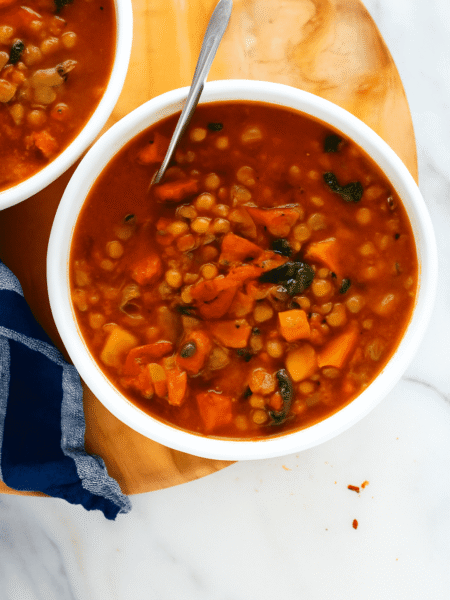 Beste vegane Linsensuppe mit Tomaten und Grünkohl in weißer Schüssel