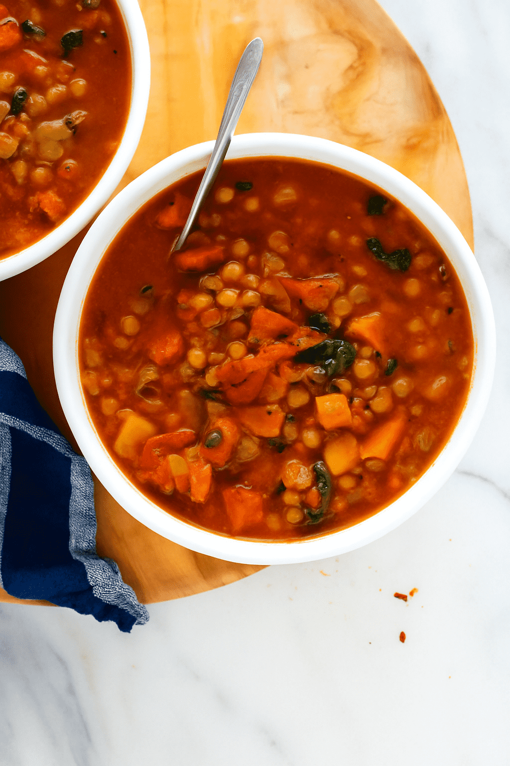 Beste vegane Linsensuppe mit Tomaten und Grünkohl in weißer Schüssel