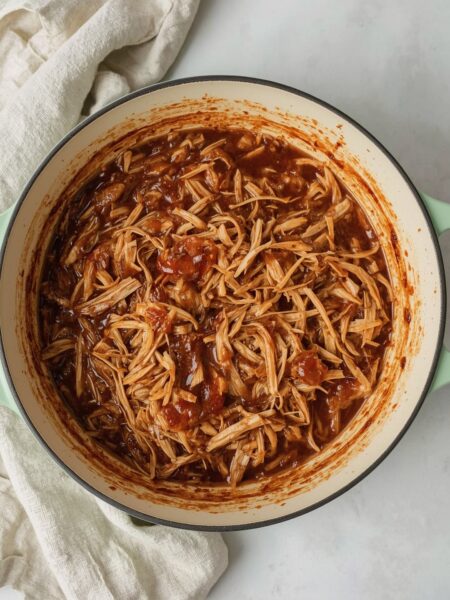 Dutch Oven Pulled Chicken – zart geschmortes Hähnchenfleisch in BBQ-Sauce, serviert direkt im gusseisernen Dutch Oven